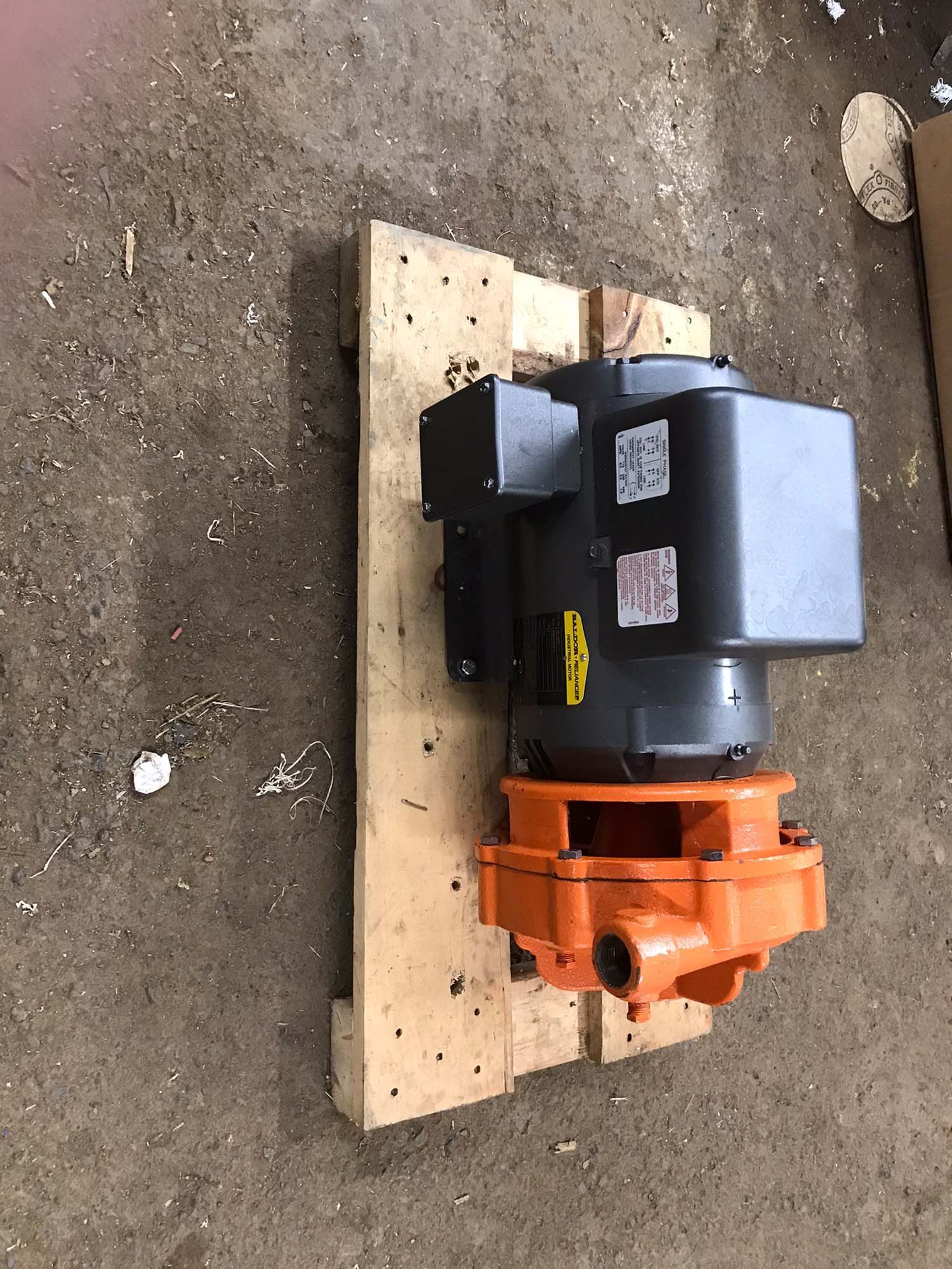 A motor is sitting on top of a wooden pallet.