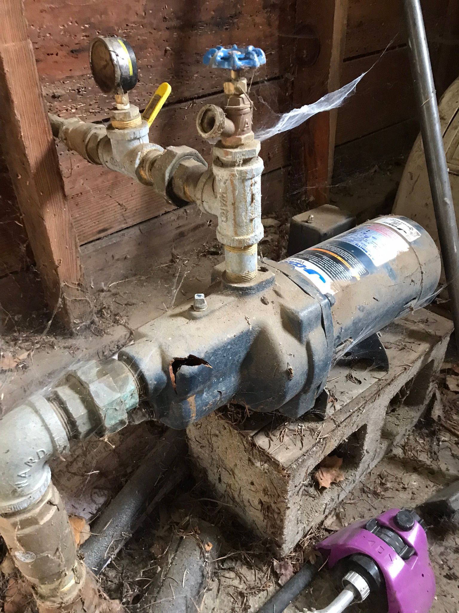 A water pump is sitting on top of a wooden block in a room.