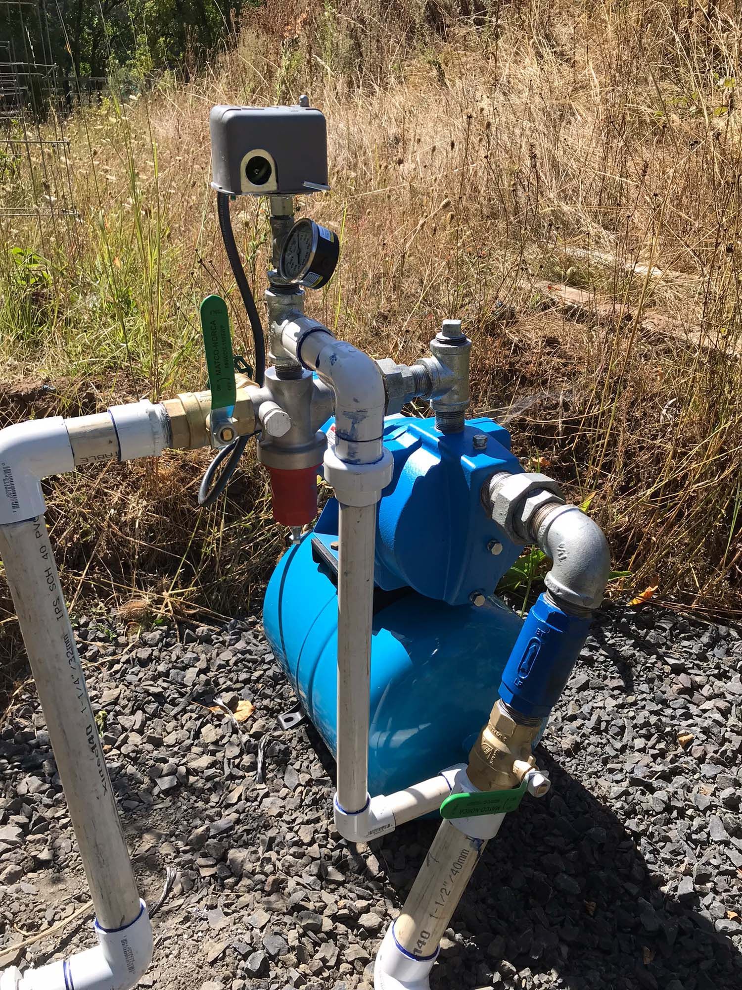 A water pump with a camera attached to it is sitting on the ground.