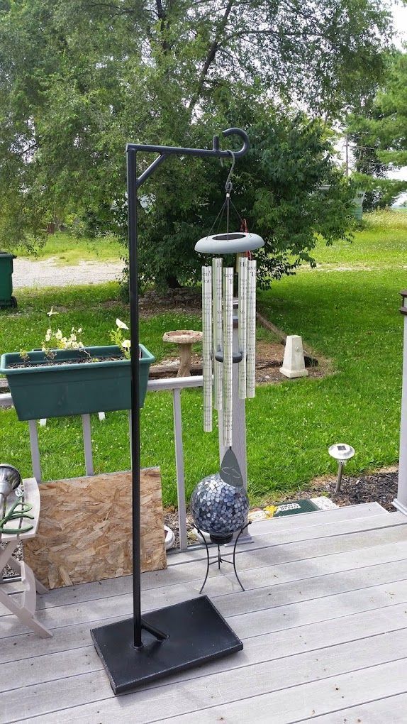 A wind chime is sitting on top of a wooden deck.