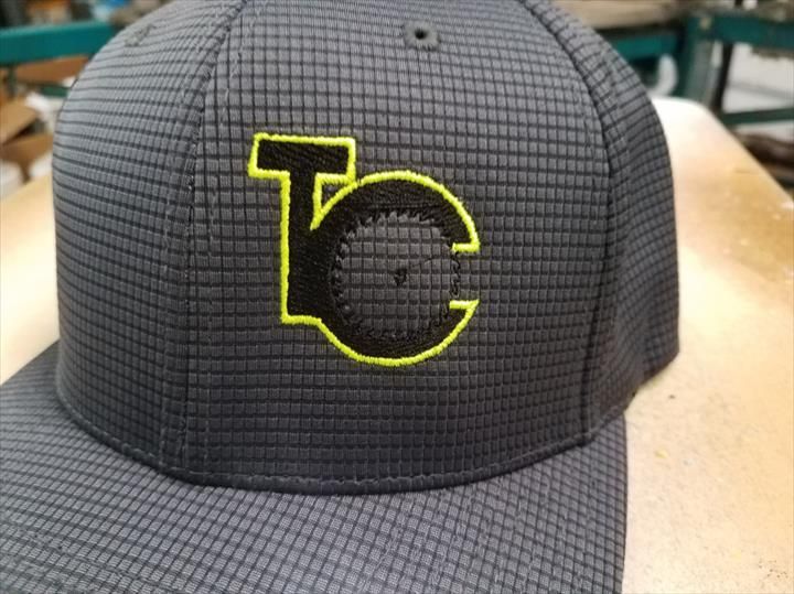 Gray baseball cap with a square pattern and the letters 