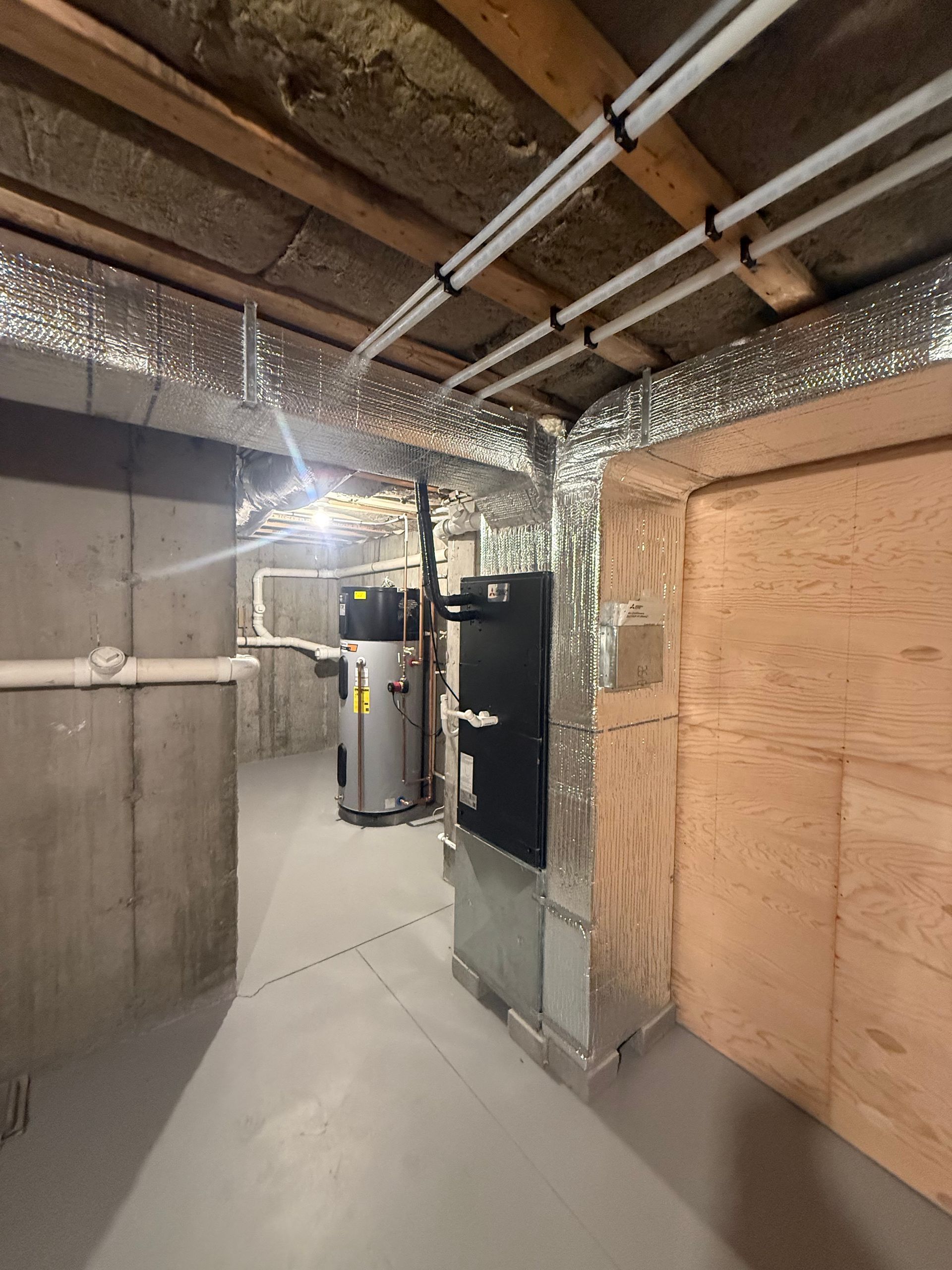 Basement with HVAC system, water heater, ductwork, insulated ceiling and concrete walls.