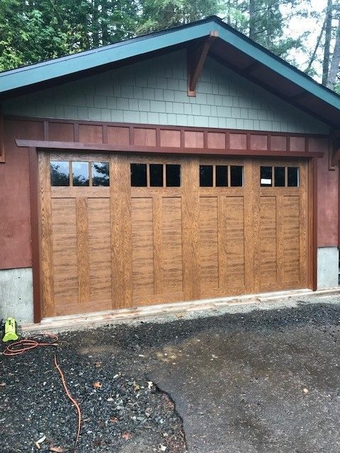 A garage with a large wooden door and windows