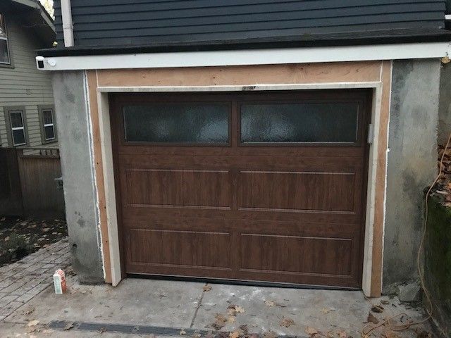 A garage door is being installed on the side of a house.