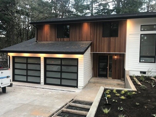 A white house with a black garage door