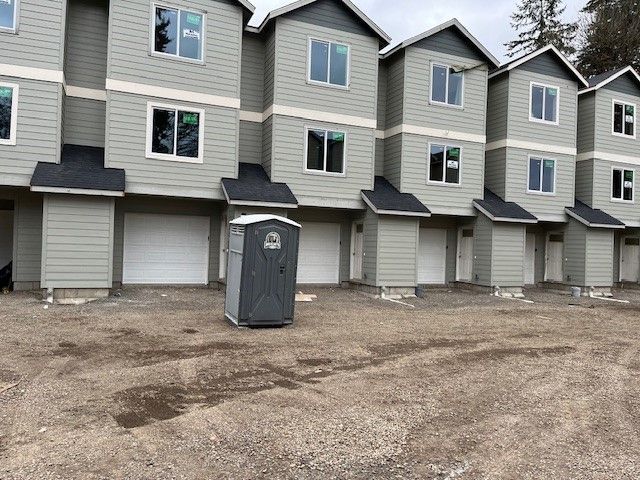 A row of apartment buildings with a portable toilet in front of them.