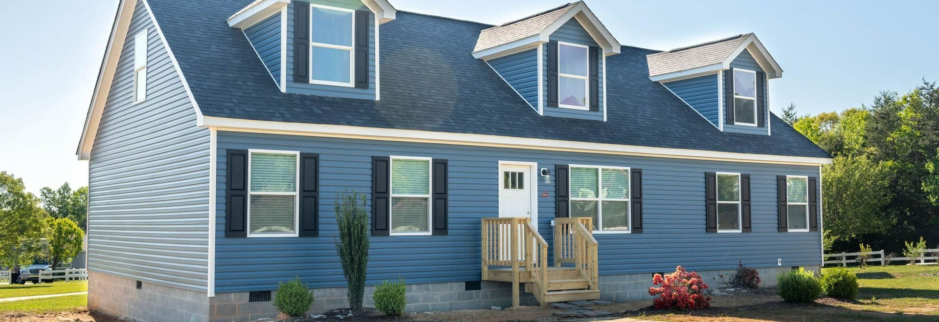 A blue and white house with a blue roof and black shutters