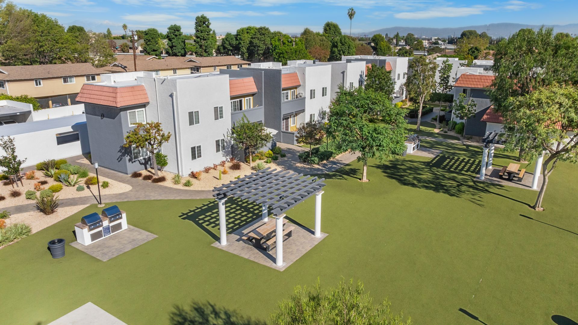 overhead view of grass field, gazebo, and apartment buildings