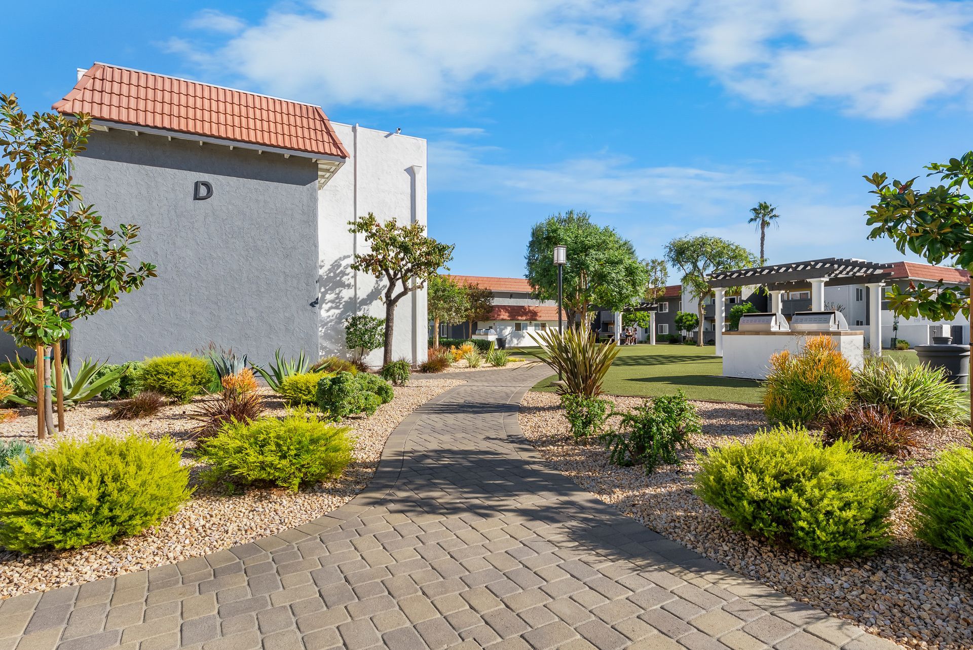 pathway lined by plants and building