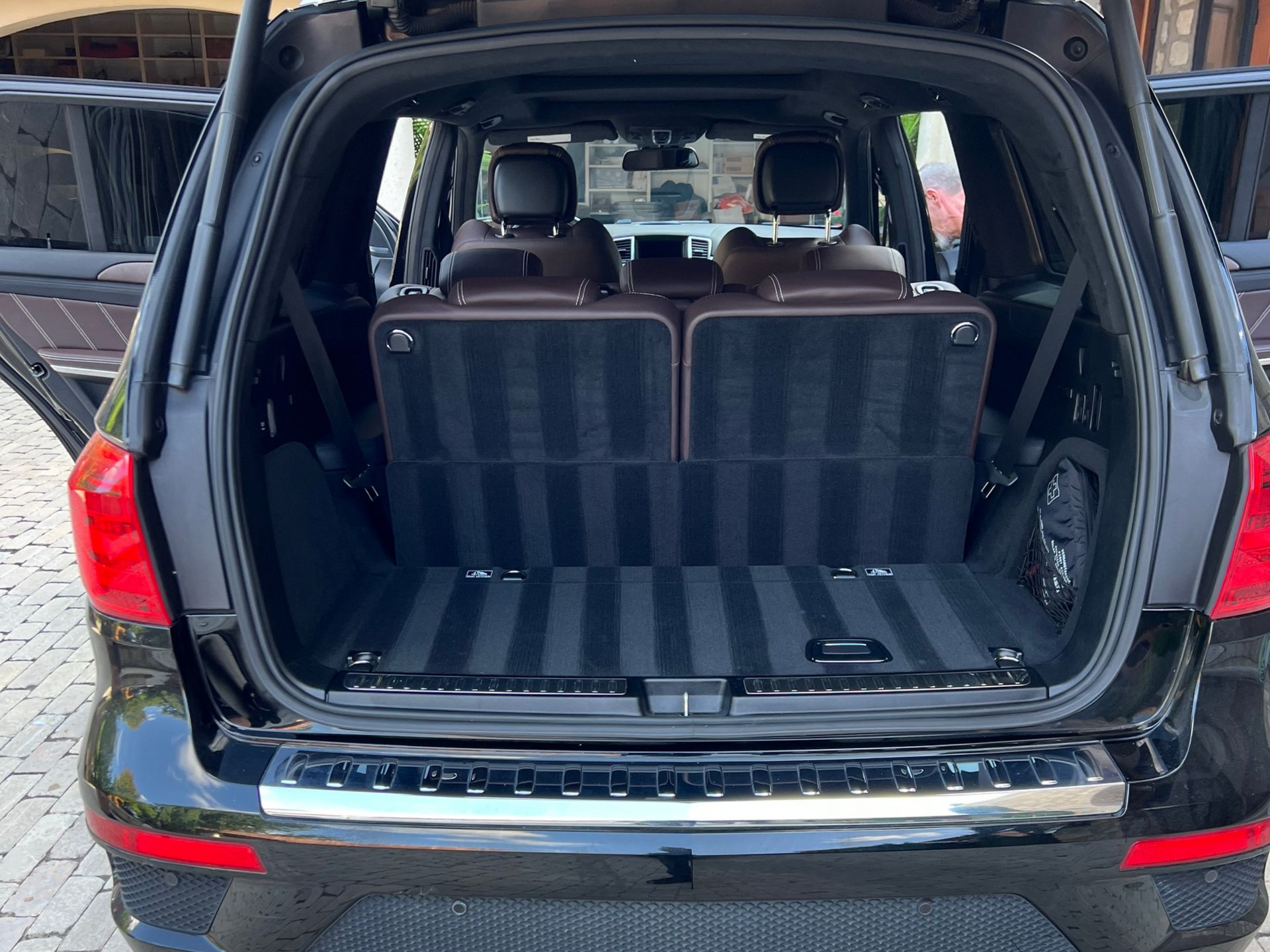 Black SUV trunk open, revealing rear seats and cargo space with dark gray carpet.