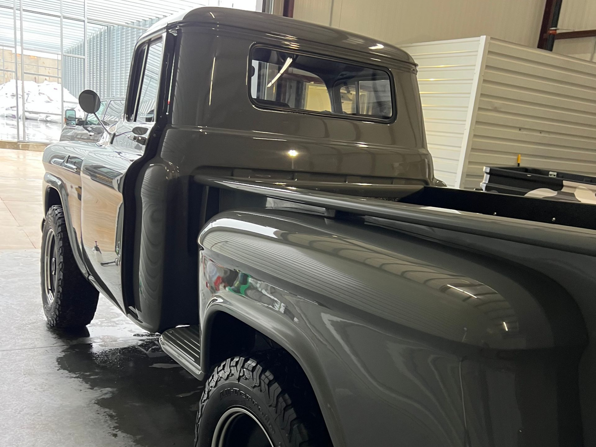 Gray vintage pickup truck. Side view showing the cab, bed, and tires.
