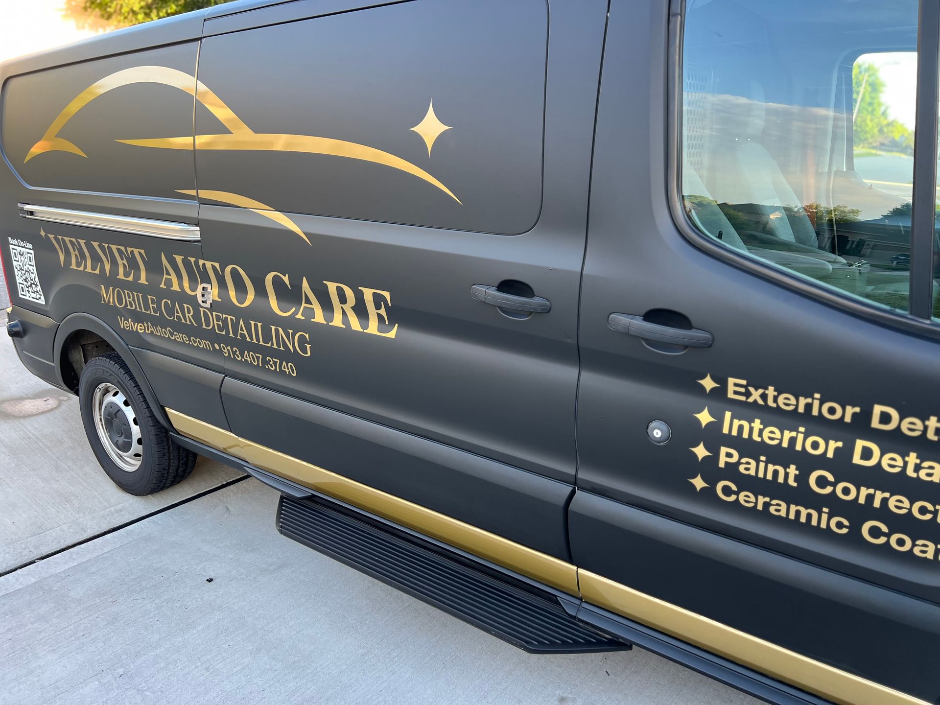 Black auto detailing van with gold lettering: