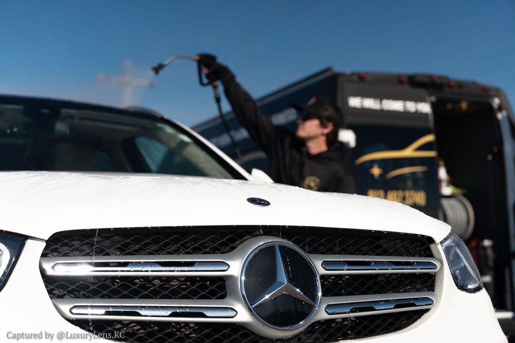Blue modified BMW coupe parked on gravel in a sunny outdoor setting.