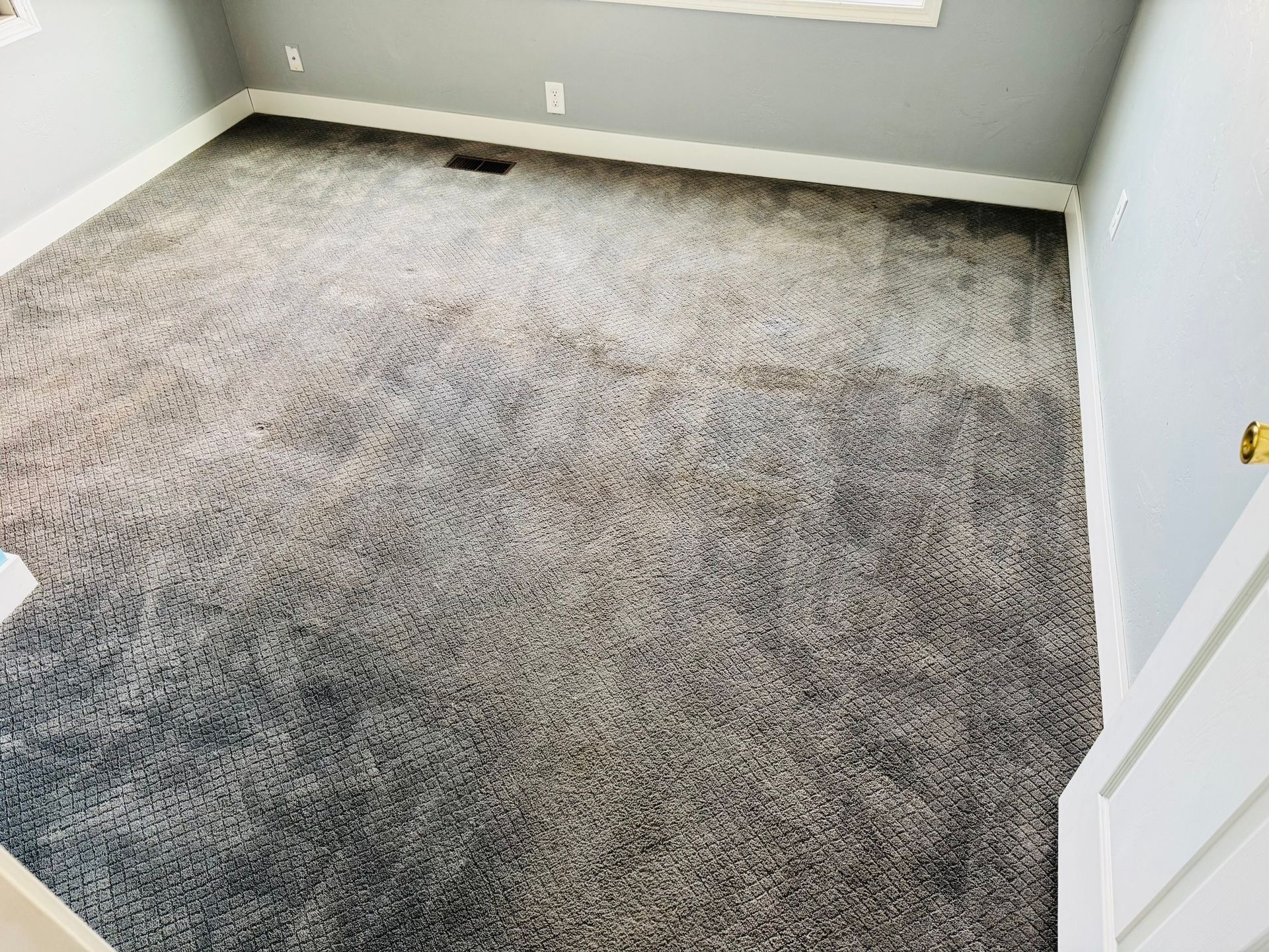 Empty room with gray-toned, multi-colored textured carpet, light gray walls, and white trim.