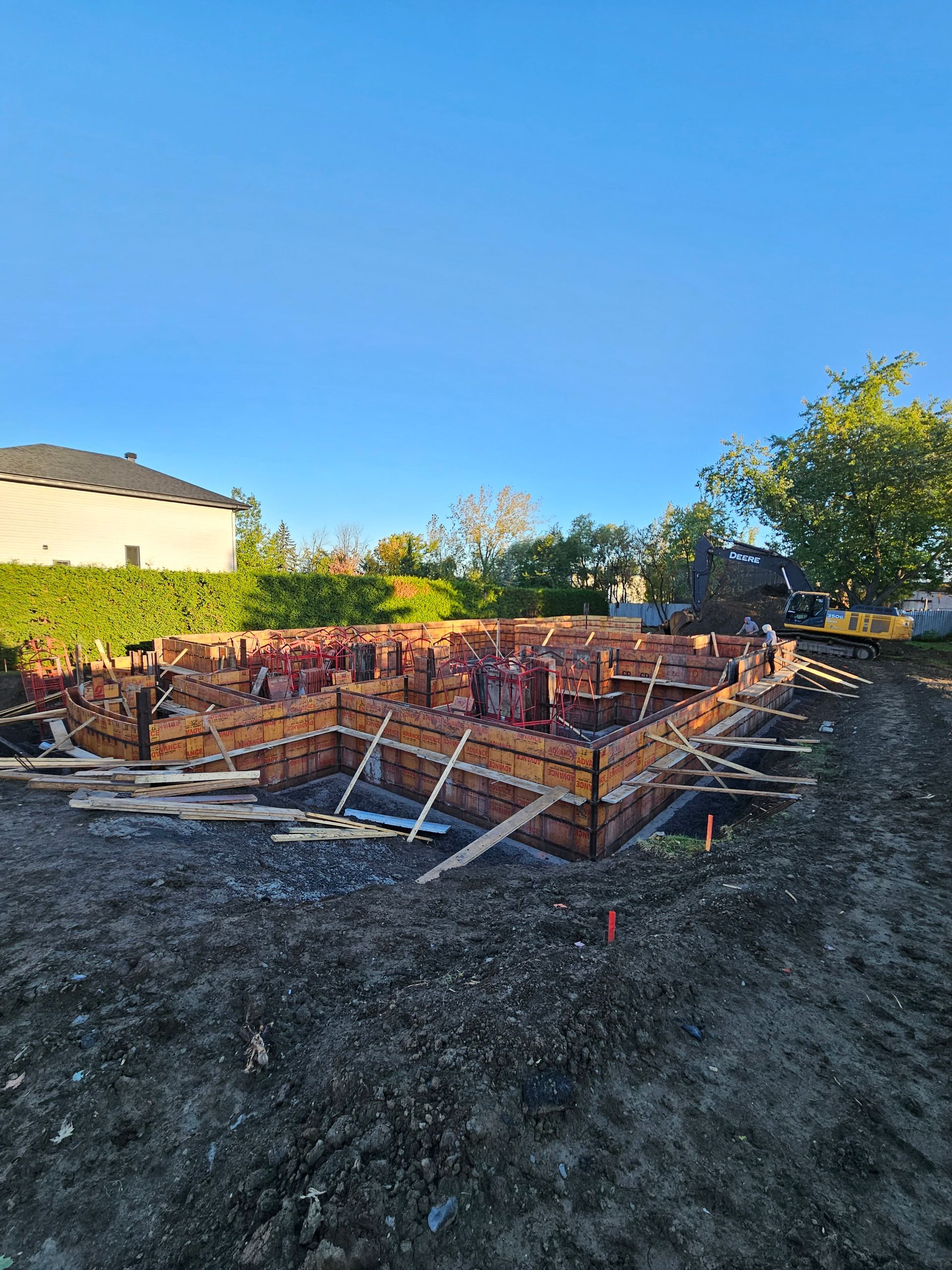 Les fondations d'une maison sont en cours de construction dans un champ de terre.