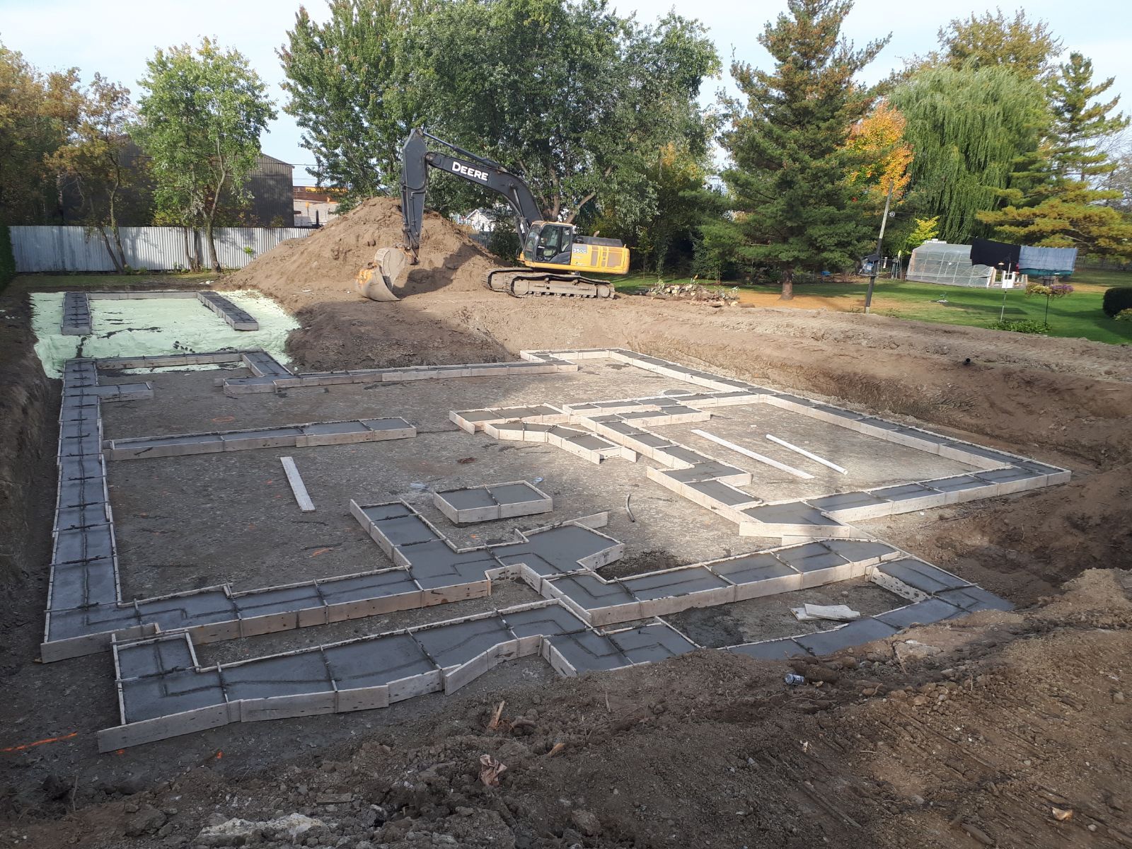 Un chantier de construction avec beaucoup de terre et d'arbres en arrière-plan.