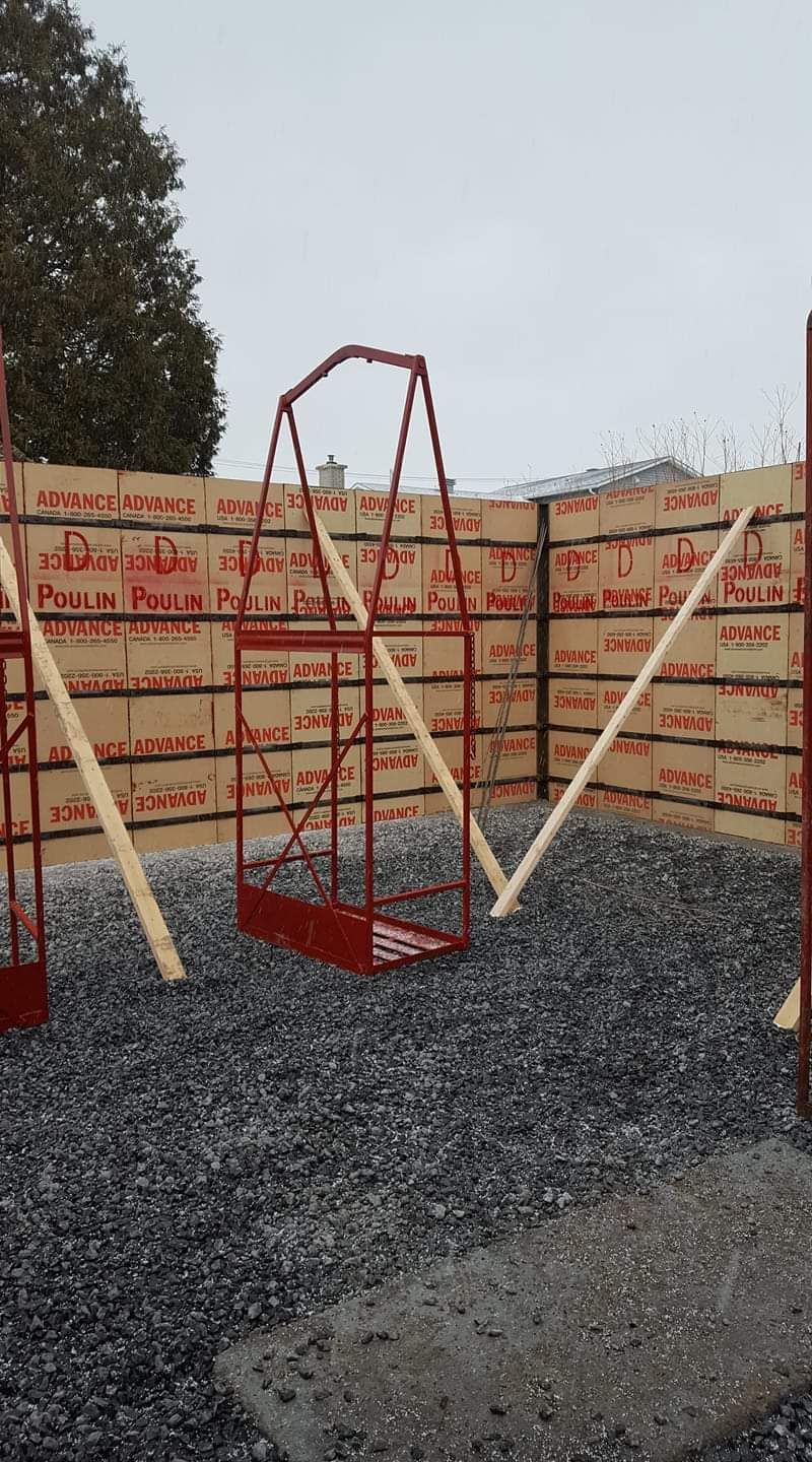 Une balançoire est en cours de construction devant une clôture.