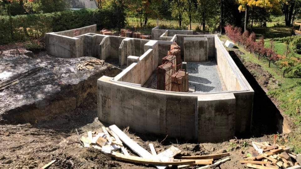 Un grand mur de béton est en cours de construction dans une cour.
