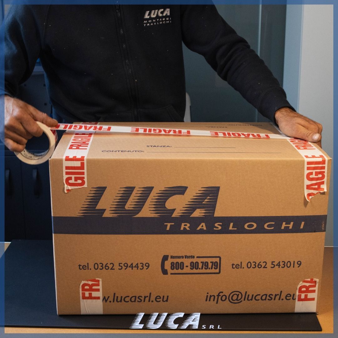 Un uomo sta avvolgendo una scatola di Luca con del nastro adesivo fragile