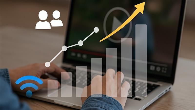 Person using a laptop with overlay icons of audience, WiFi, and an upward graph, symbolizing adaptiv