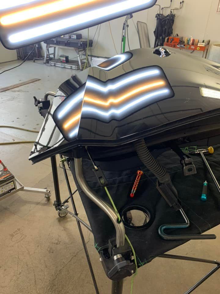 A black car is sitting on top of a table in a garage.
