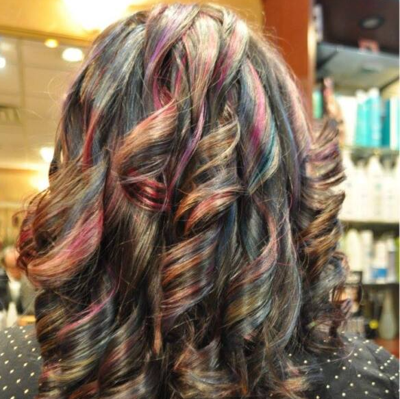 The back of a woman 's head with colorful hair.
