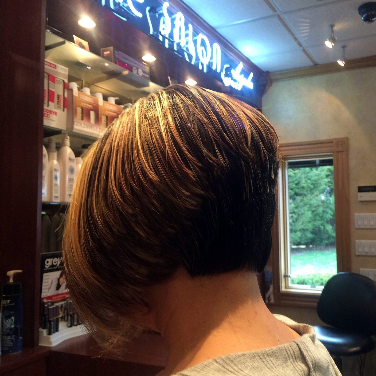 A woman 's back is shown in front of a sign that says loreal