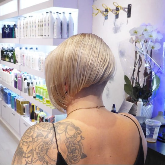 A woman with a tattoo on her back is standing in a store