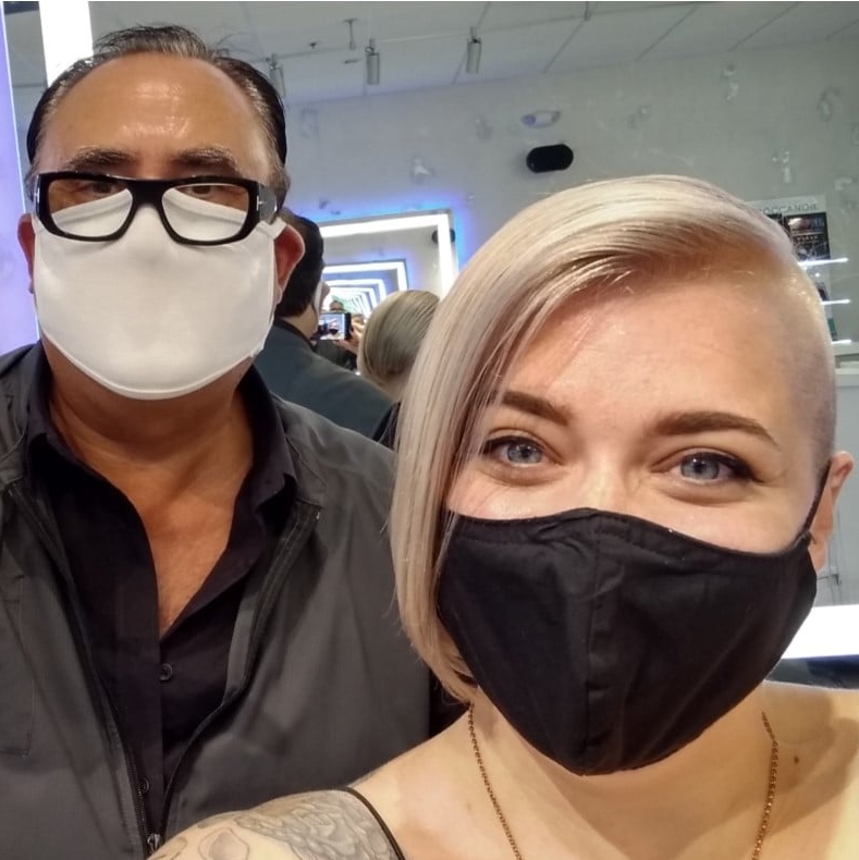 A man and a woman wearing face masks are posing for a picture