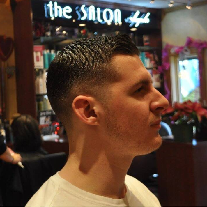 A man standing in front of a sign that says the salon