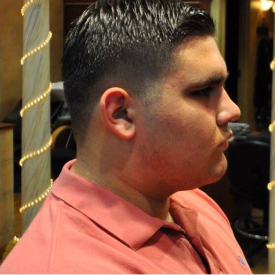 A man in a pink shirt is looking to the side