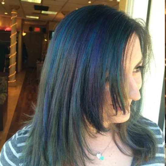 A woman with blue hair is wearing a striped shirt