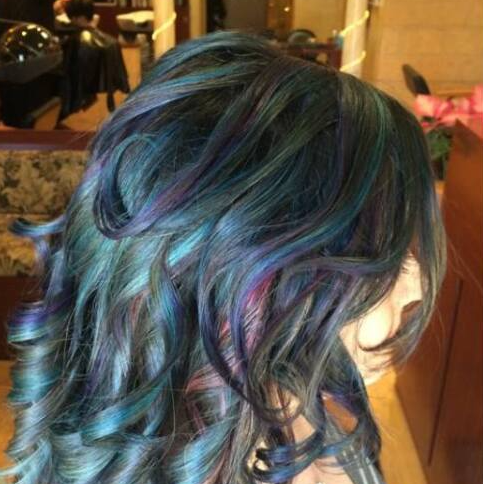 A close up of a woman 's hair with blue and purple highlights.