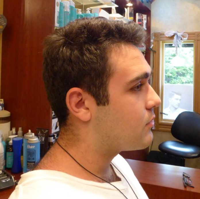 A man in a white shirt is in a barber shop