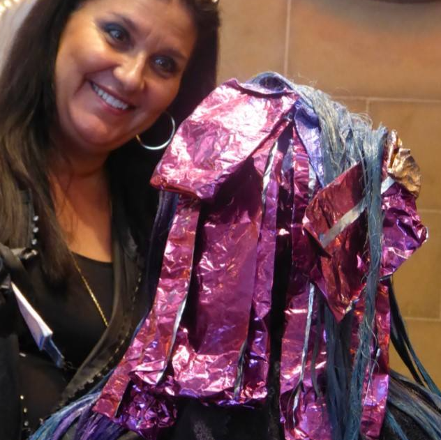 A woman is holding a bunch of purple and blue foil