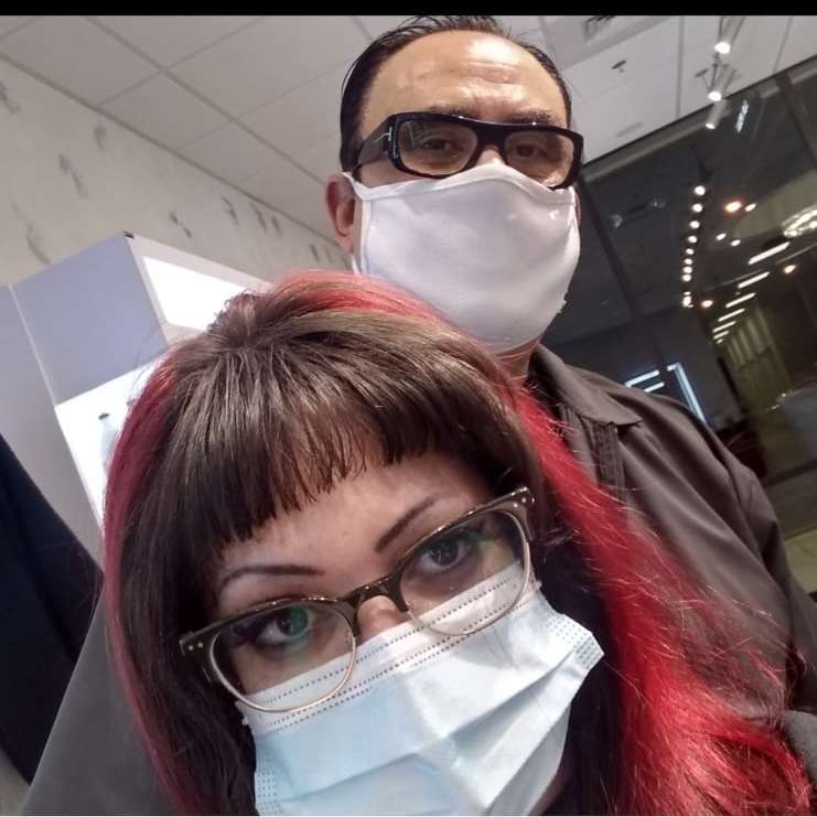 A man and a woman wearing face masks and glasses