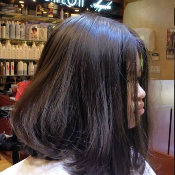 A woman is getting her hair cut in a salon