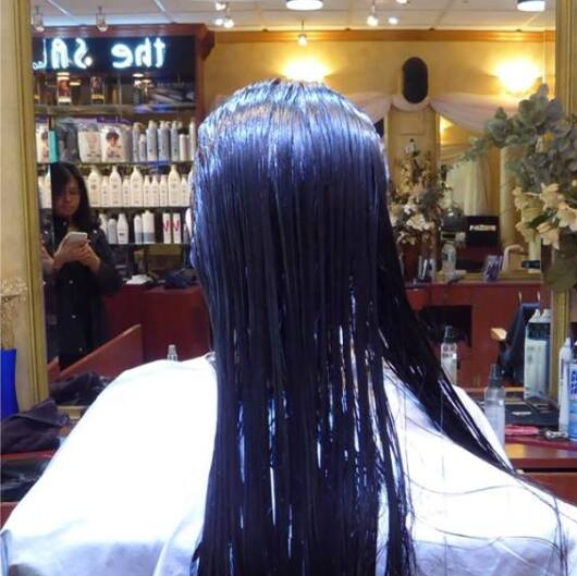 A woman is getting her hair cut in a salon