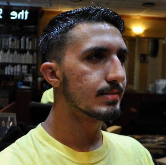 A man with a beard is wearing a yellow shirt