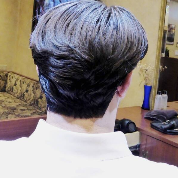The back of a person 's head with a white shirt on