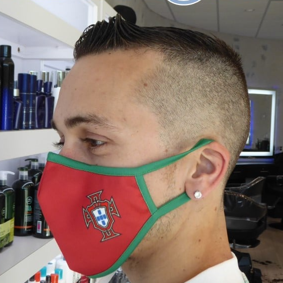 A man wearing a red and green face mask with the portuguese flag on it