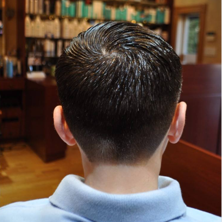 The back of a man 's head with a blue shirt on