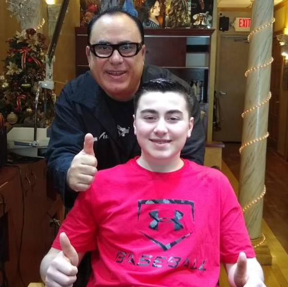 A man giving a thumbs up next to a boy wearing a red under armour shirt