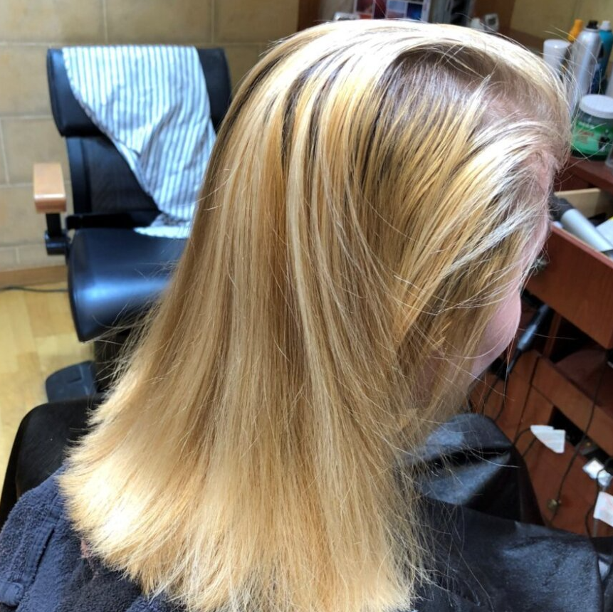 A woman with blonde hair is sitting in a chair