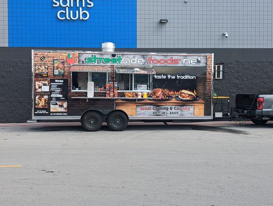 A food truck is parked in front of a sam 's club