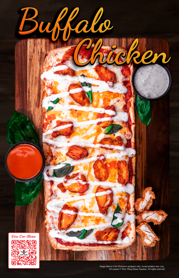 Buffalo chicken pizza on wooden board with sauce, ranch, basil.