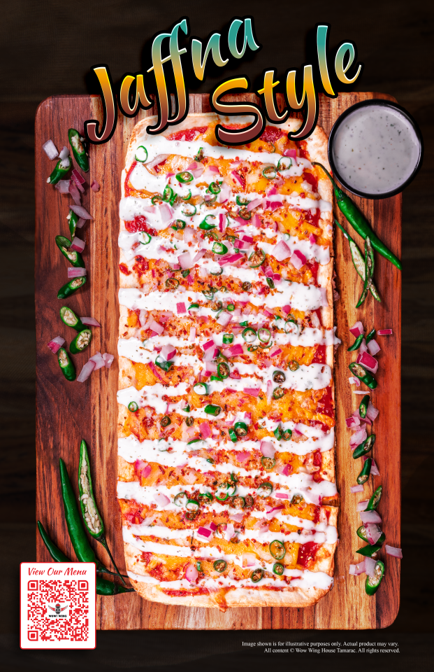 Jaffna Style flatbread on wooden board, topped with sauce, onions, peppers, and a side of sauce.