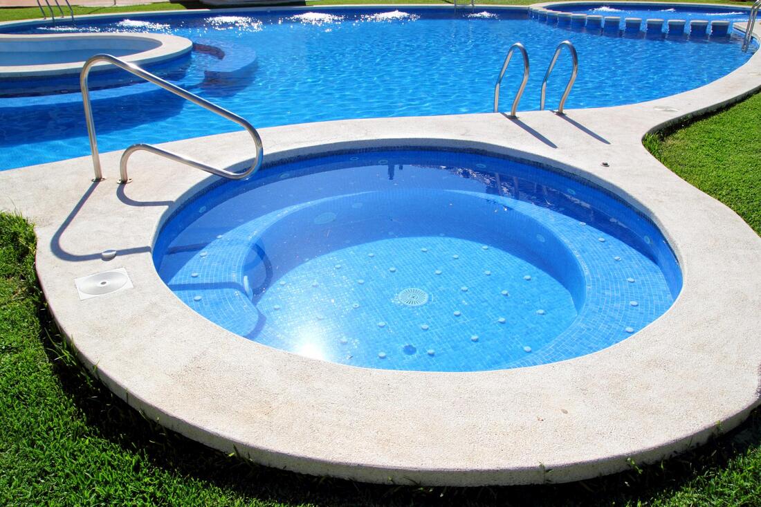 a clean and wide pool and hot tub