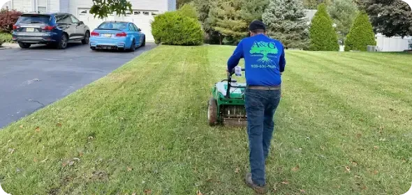 Owner of landscaping company standing in front of completed residential landscaping project