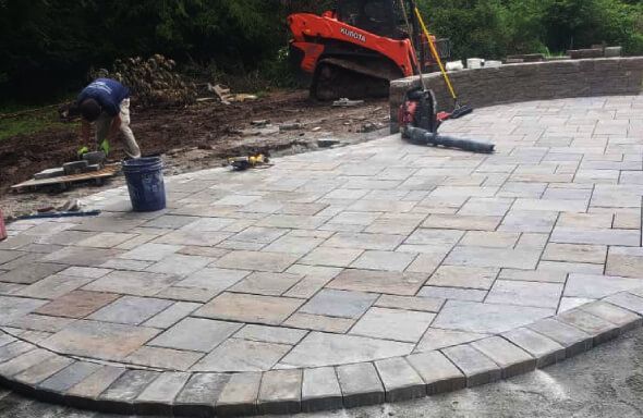 Paver patio installation process in NJ with deep excavation, compacted gravel base, and proper joint sealing